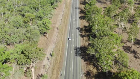 Isolated-car-driving-on-deserted-road-at-St-Lawrence,-Clairview-in-Australia