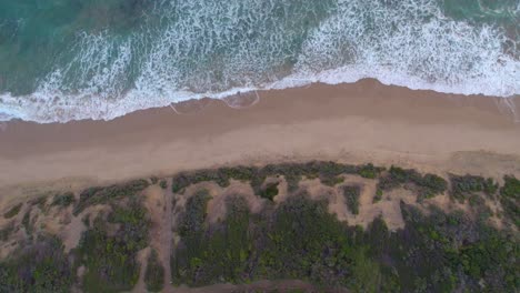 Vertical-slow-moving-drone-footage-of-the-dunes,-beach-and-waves-at-Point-Lonsdale,-Victoria,-Australia