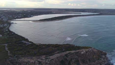 Drone-footage-flying-over-the-Baron-Heads-Bluff-towards-the-mouth-of-the-Barwon-River-at-Barwon-Heads,-Victoria,-Australia