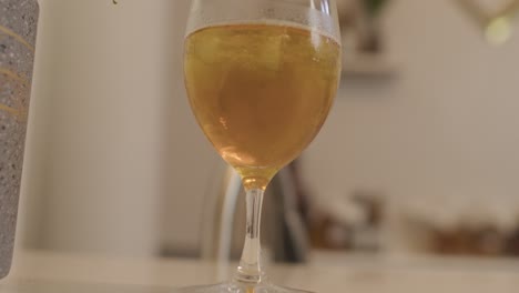 Un-Vaso-De-Bebida-De-Kombucha-En-Una-Mesa-De-Bar-Blanca