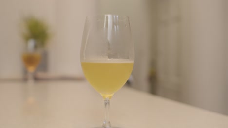 Un-Vaso-De-Bebida-De-Kombucha-En-Una-Mesa-De-Bar-Blanca