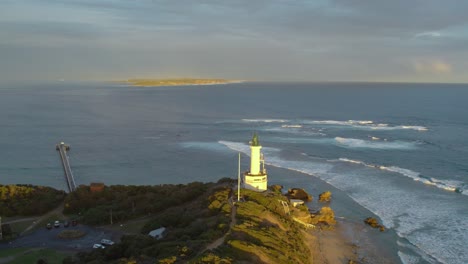 Aerial-view-at-sunset-over-the-Point-Lonsdale-lighthouse,-and-Port-Philip-Bay-heads-towards-Point-Nepean