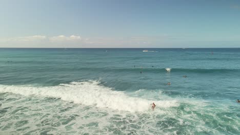 Vista-Aérea-De-Surfista-Montando-Olas-En-Un-Soleado-Día-Hawaiano-Con-Cielo-Azul