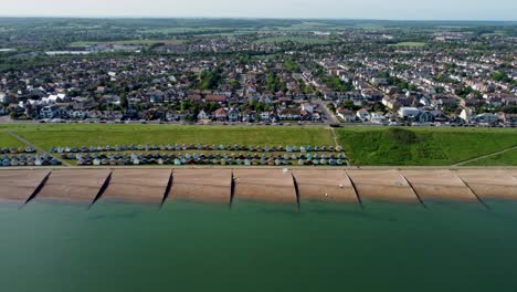 A-dolly-left-aerial-flyover-of-Tankerton-beach,-with-a-view-of-the-town-and-beach-houses-in-the-background
