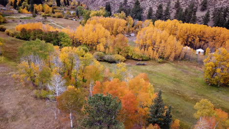Aerial-View-of-Colorful-Landscape-in-American-Countryside,-Yurt-Tents-and-Forest-in-Vivid-Foliage,-Drone-Shot