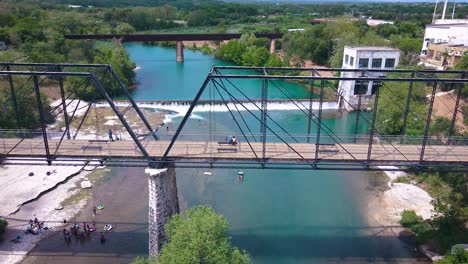 Drone-footage-of-the-historic-Faust-Street-bridge-in-New-Braunfels,-Texas-that-goes-over-the-Guadalupe-River-near-Interstate-35