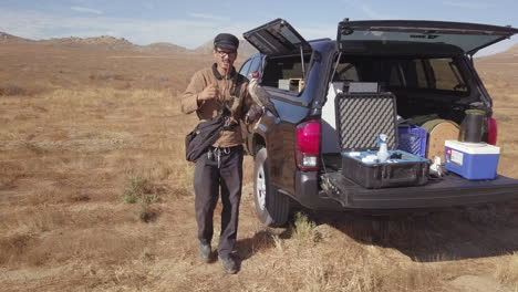 Man-Doing-Falconry-Training-with-Falcon-Gets-Gear-Equipment-from-Truck