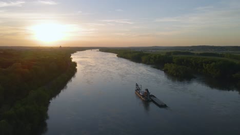 Aerial-view-around-a-river-sand-dredging-machine,-sunset-in-Missouri,-USA---circling,-drone-shot
