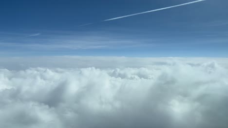 Vista-Aérea-Del-Cielo-Desde-Una-Cabina-De-Jet-Mientras-Sobrevuela-Nubes-Blancas-Durante-El-Nivel-De-Crucero