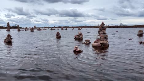 Piles-of-stones-in-a-small-lake-on-top-of-a-Swedish-mountain-in-Sälen,-Dalarna