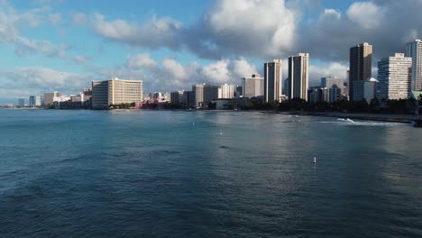 4k-Filmische-Drohnenaufnahme-Von-Waikiki-Beach-Und-Hotels-Direkt-über-Dem-Wasser,-Während-Die-Wellen-In-Oahu-Brechen
