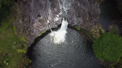 4K-Filmische-Drohnenaufnahme-Eines-Wasserfalls,-Der-Sich-über-Eine-Lavafelsenklippe-In-Der-Nähe-Des-Regenwaldes-In-Hilo-Auf-Der-Großen-Insel-Hawaii-Ergießt