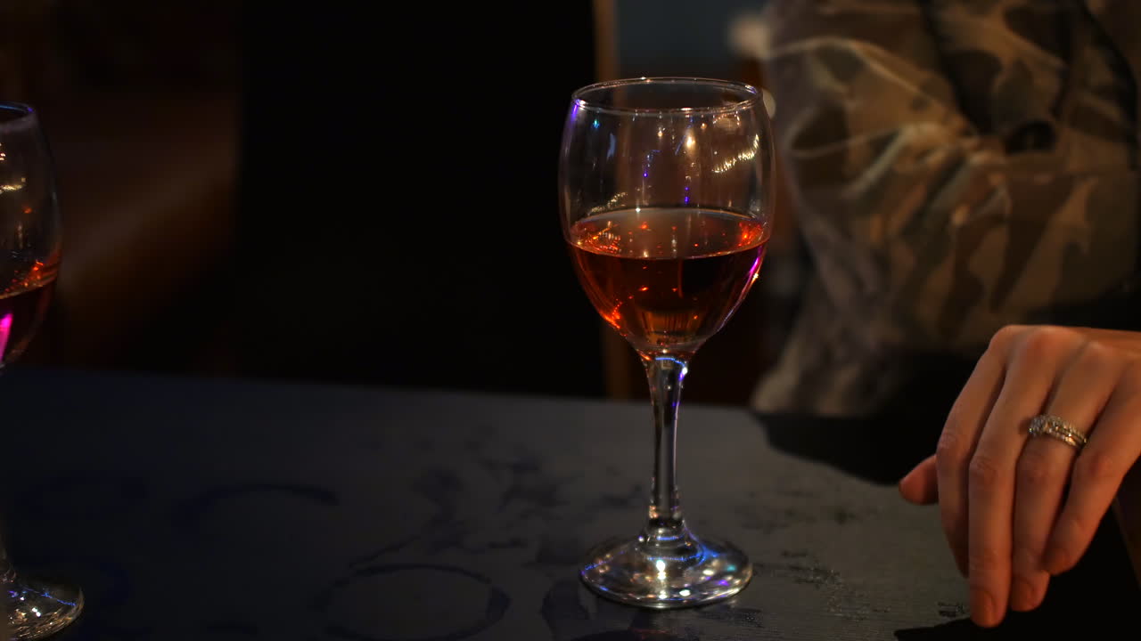 Premium stock video - Woman drinking rose wine in a dark pub bar