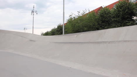 Skateboarder-Springt-Mit-Hoher-Geschwindigkeit-Auf-Eine-Betonrampe-Und-Fährt-Hinunter