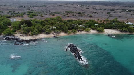 4K-cinematic-counterclockwise-drone-shot-of-Waialea-Beach-and-the-lava-rock-island-that-is-present-within-the-water
