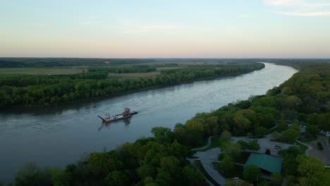 Aerial-view-around-a-dredging-machine-at-the-Missouri-river,-dusk-in-USA---circling,-drone-shot