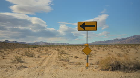 Sign-with-arrow-pointing-direction-highway-in-California-desert