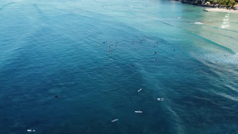 4K-cinematic-drone-reveal-shot-panning-from-surfers-trying-to-catch-a-wave-at-Waikiki-Beach-to-the-Oahu-coastline