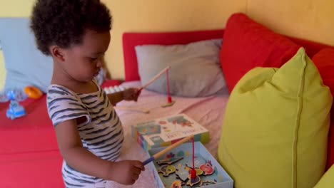 Zwei-Jahre-Altes-Süßes-Afroeuropäisches-Kind,-Das-Sich-Mit-Einem-Angelspielzeug-Amüsiert