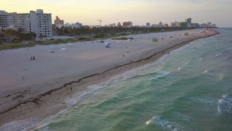 Aerial-view-overlooking-people-at-the-South-Point-beach,-sunset-in-Miami,-USA