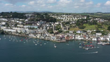 Wide-aerial-orbit-of-Fowey-Parish-Church-and-Porphry-Hall,-with-the-Harbor-and-Cornish-town-of-Fowey,-UK