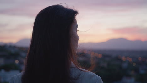 Medium-close-up-of-the-side-profile-of-a-young-white-woman-during-the-sunset-or-sunrise-with-mountain-landscape