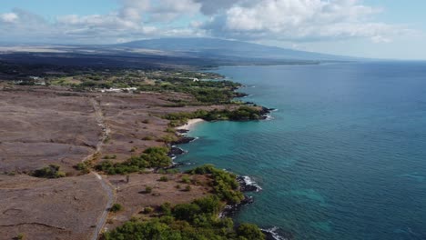 4K-cinematic-drone-shot-of-the-desert-and-volcano-in-the-background-on-the-coast-near-Kona-on-the-Big-Island-of-Hawaii