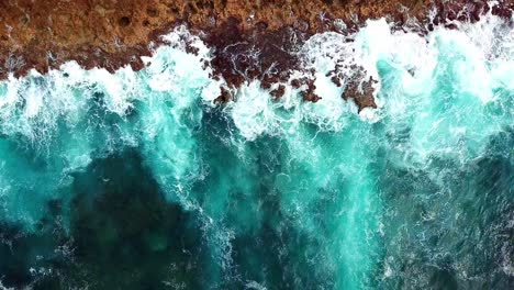 Overhead-static-view-of-the-strong-waves-of-pristine-waters-against-the-rocks-on-the-shores-of-Curacao,-a-Dutch-Caribbean-island