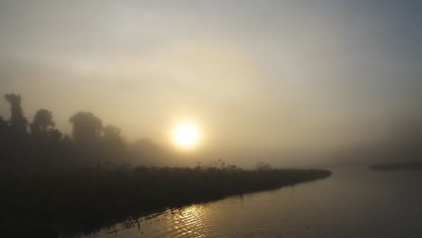 Dreamy-Misty-Dawn-by-the-Serene-Oxbow-lake-in-the-Peruvian-Rainforest-,-sun-covered-by-mist