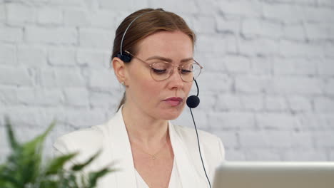 A-technical-support-customer-service-worker-talking-into-a-headset-in-an-office