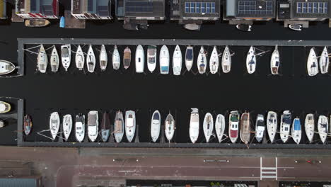 Aerial-footage-of-sailing-boats-at-a-harbor-at-Bunschoten-Spakenburg,-The-Nederland-Flying-upwards