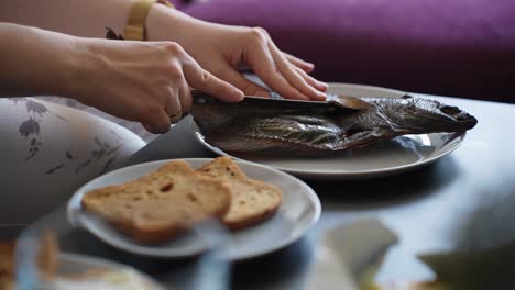 Smoked-Fish-Meal-with-Bread-for-Breakfast,-Female-Hands-Cutting-Fish
