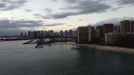 4K-cinematic-crane-drone-shot-of-the-Northwest-side-of-Waikiki-and-the-marina-in-Oahu-during-sunset