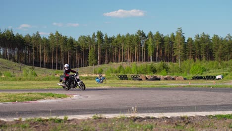 Motorcycle-driver-slowing-turning-and-examing-race-track,-handheld-view