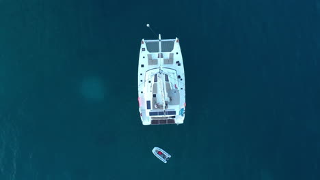 Aerial:-Yacht-anchored-in-the-ocean---Bird's-eye-view-flying-downward
