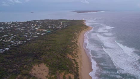 Aerial-view-along-the-coast-looking-towards-the-lighthouse,-and-Port-Philip-Bay-heads-towards-Point-Nepean