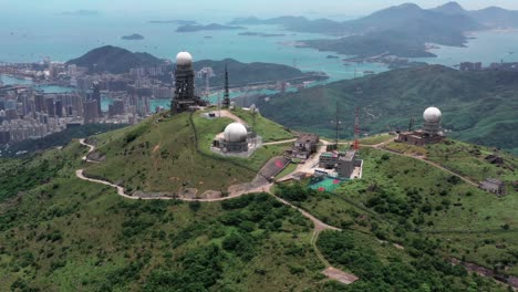 Luftaufnahme-Der-Aufgehenden-Sonne-Am-Höchsten-Berg-Tai-Mo-Shan-In-Hongkong-Mit-Buntem-Blauem-Meer-Und-Hohen-Wolkenkratzern-Im-Hintergrund