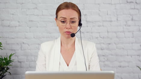 A-technical-support-customer-services-agent-is-working-in-an-office-and-talking-on-the-phone