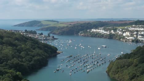 Aerial-view-over-the-River-Fowey,-In-South-Cornwall,-UK-looking-towards-the-town-of-Fowey-and-Polruan-towards-the-sea