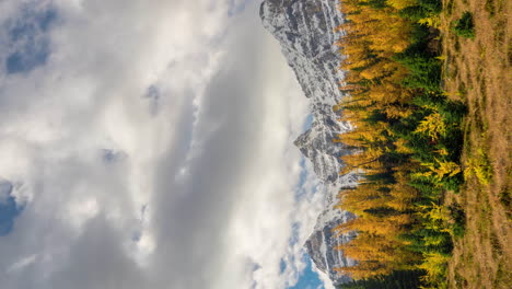 Vertical-4k-Time-Lapse,-Autumn-Season-in-Mountain-Range-of-Canada,-Larch-Forest-Valley,-Snow-Capped-Peaks-and-Clouds