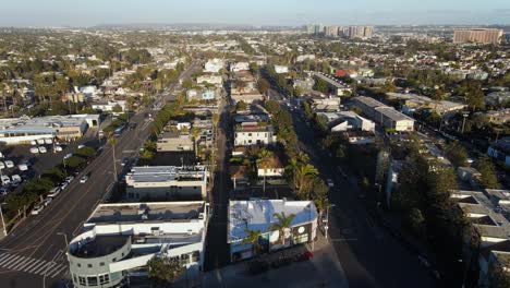 Aerial-view-overlooking-the-cityscape-of-Venice,-golden-hour-in-Los-Angeles,-USA---tilt,-drone-shot