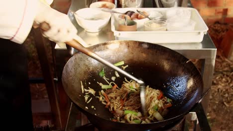 Kuy-Teav-Cha-or-Cambodian-stir-Fried-egg-noodle-being-cooked-in-a-traditional-wok-at-a-streetfood-stall-shot-in-slow-motion