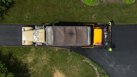 Top-down-aerial-rising-shot-of-truck-paving-driveway