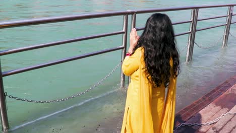 Isoliertes-Junges-Mädchen,-Das-Den-Heiligen-Gangesfluss-Am-Flussufer-Aus-Einem-Flachen-Winkelvideo-Heraushebelt,-Wird-Am-Ganga-flussufer-Haridwar-Uttrakhand-Indien-Aufgenommen