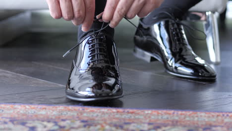 Male-Tying-Shoe-Laces-On-Shiny-Black-Glossy-Formal-Shoes
