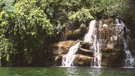 Kleiner-Wasserfall-In-Der-Natur-Tagsüber,-Blick-Nah-An-Der-Wasseroberfläche,-Großer-Baum-Umgibt-Den-Wasserfall