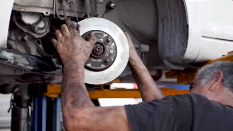 Grizzled-Mexican-Mechanic-Adjusting-the-Brake-Disc-of-a-Car-Recently-Rectified-For-a-Latino-Customer