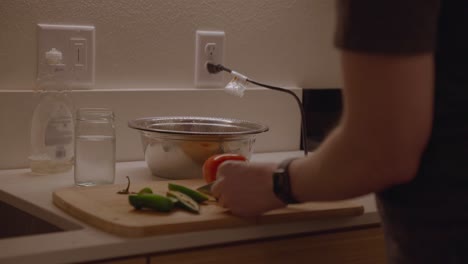 Male-preparing-homemade-pasta-sauce-in-modern-kitchen-at-night-time