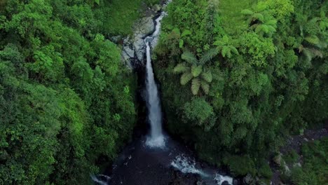 Luftaufnahme-Des-Kedung-Kayang-Wasserfalls-Am-Morgen,-Der-Von-Grünem-Wald-Umgeben-Ist,-Zieht-Touristen-An