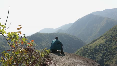 Joven-Aislado-En-La-Cima-De-La-Montaña-Con-Bosques-Verdes-Y-Cielo-Azul-Brumoso-Por-La-Mañana-Desde-Un-Video-De-ángulo-Plano-Tomado-En-Mawryngkhang-Trek-Meghalaya-India
